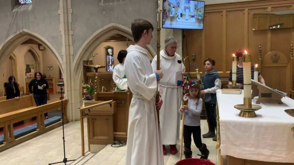 Servers and children carrying candles and a cross during a Sunday service at St. Timothy's