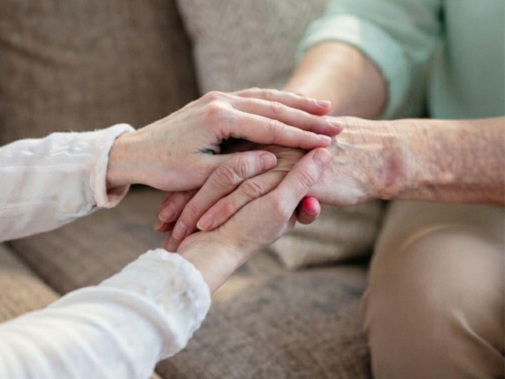 Two people holding hands in a moment of comfort