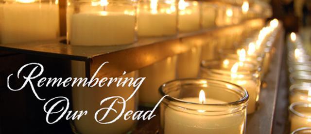 Rows of lit candles in glass holders